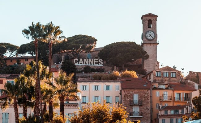 Vue du vieux Cannes avec le clocher du Suquet et l’enseigne CANNES au coucher du soleil
