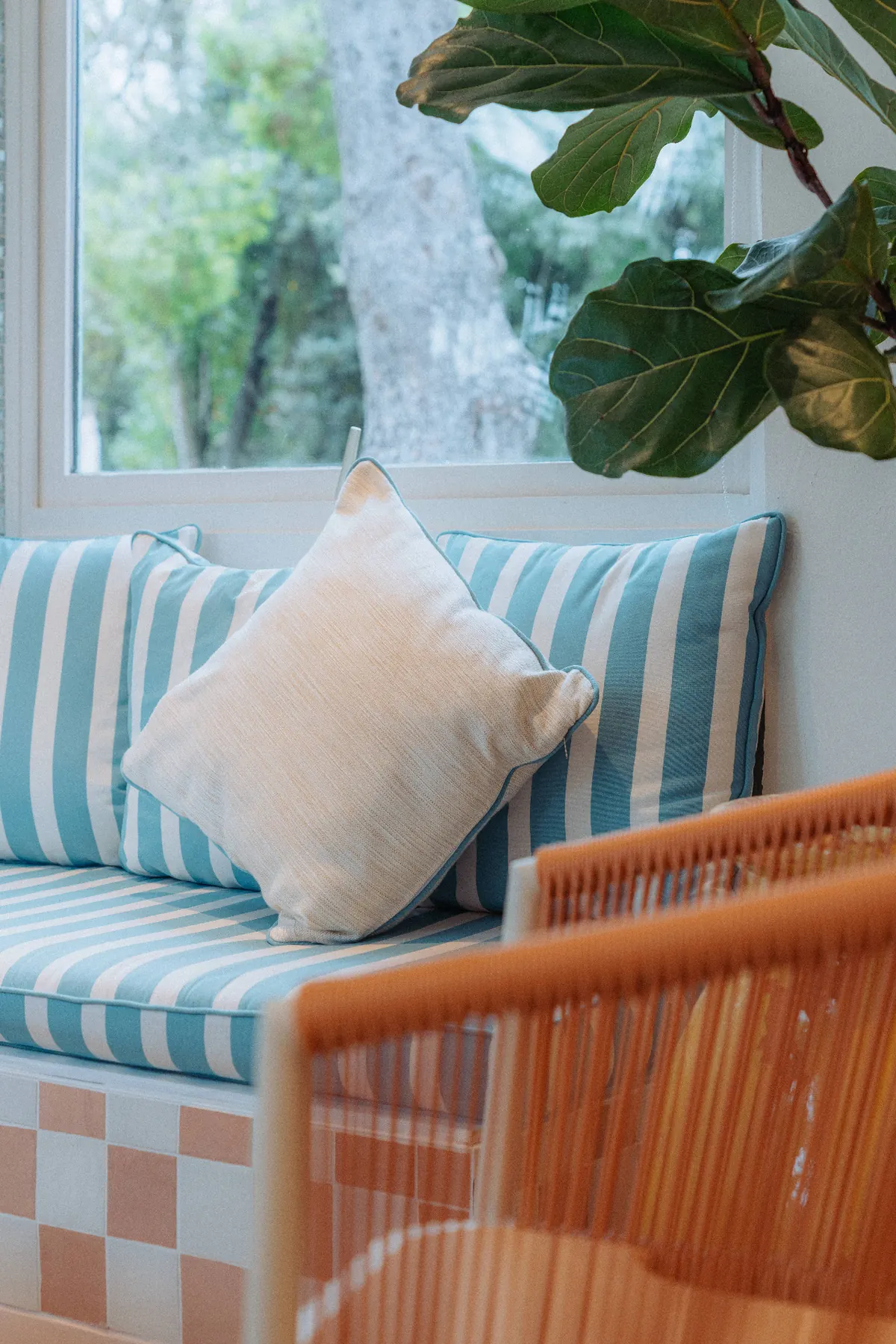 Détail banquette rayée et coussin lin dans le salon du The Cannes Motel